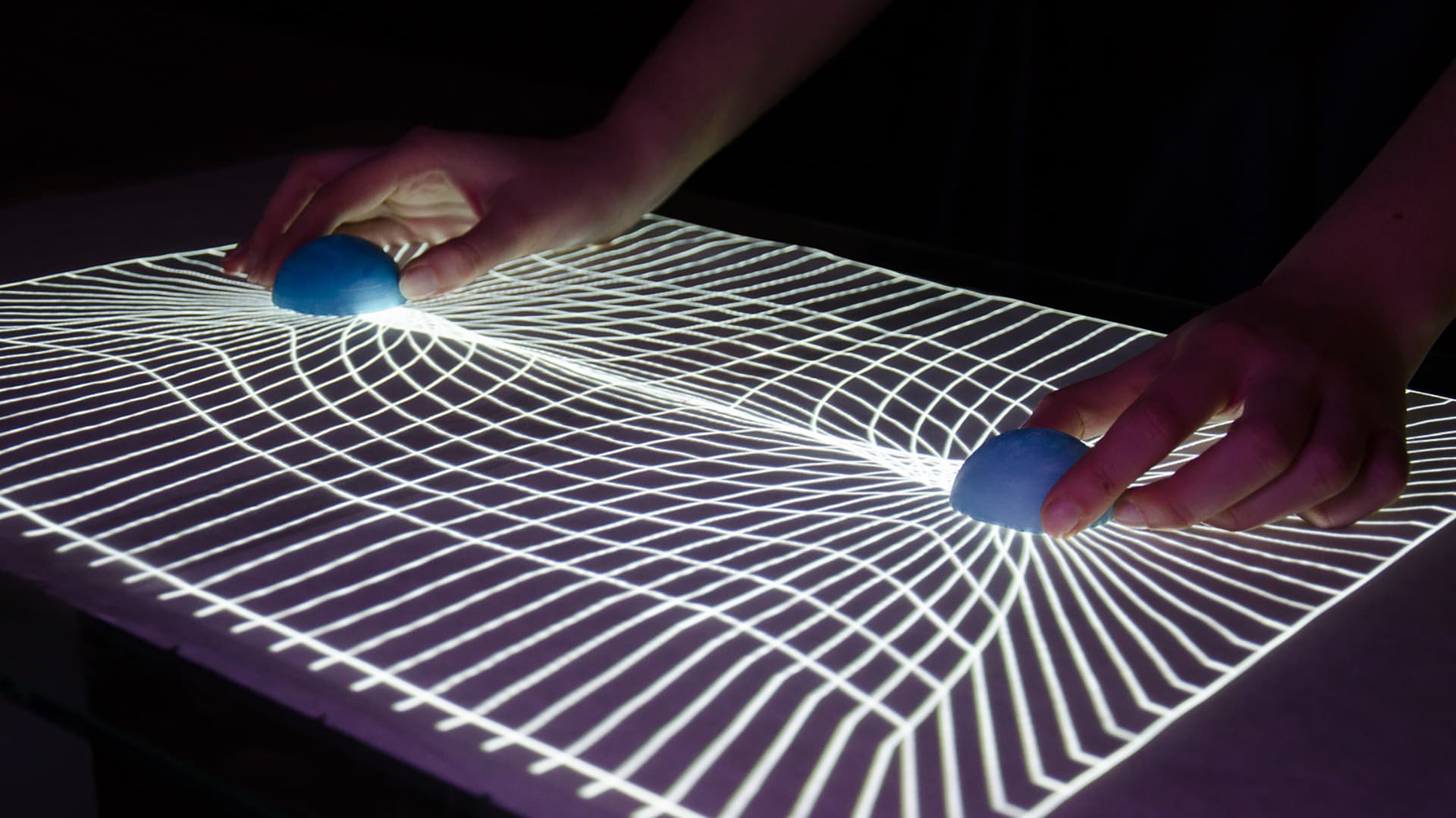 Gravitation of two planets on tangible table